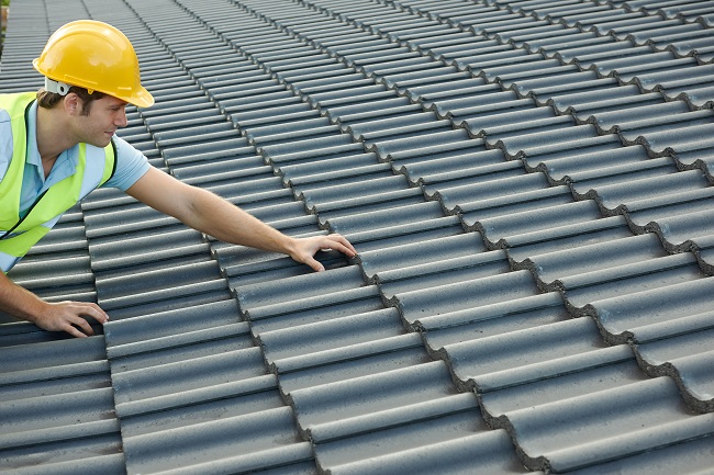 Builder Working On Roof Of New Building Vera Roofing Construction